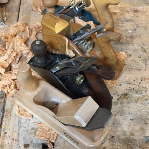 four woodworking planes on a bench